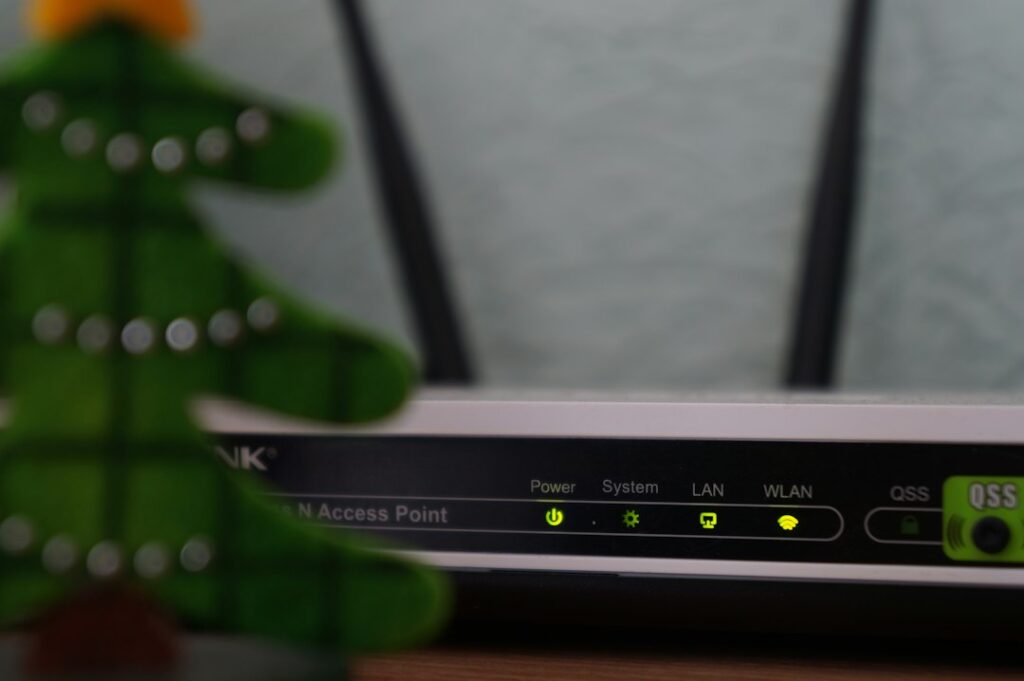 A resident checks a router beside a laptop while testing internet speed at home.