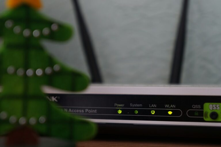 A resident checks a router beside a laptop while testing internet speed at home.